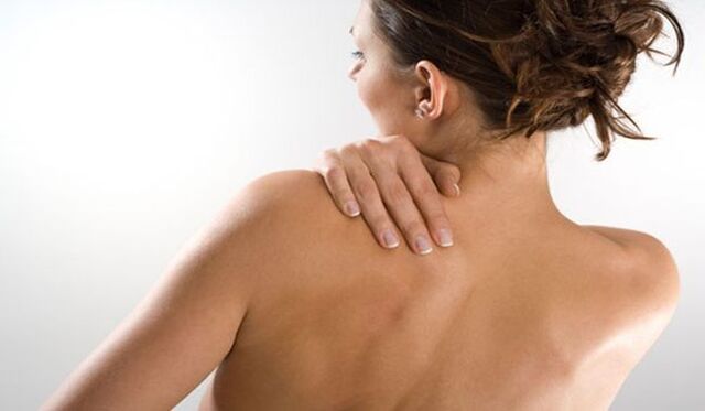 Η γυναίκα ανησυχεί για τον πόνο κάτω από την αριστερή ωμοπλάτη στην πλάτη από την πλάτη